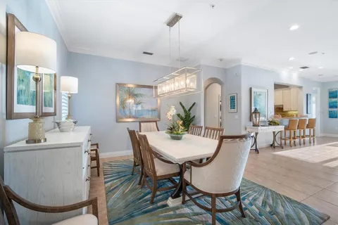 a kitchen with stainless steel appliances kitchen island granite countertop a table and chairs in it