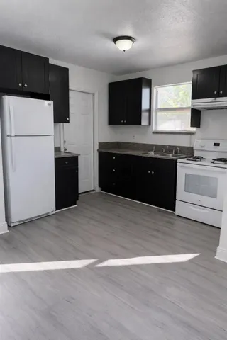 a kitchen with a refrigerator and a stove top oven