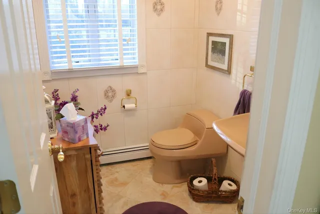 a bathroom with a toilet a sink and a window