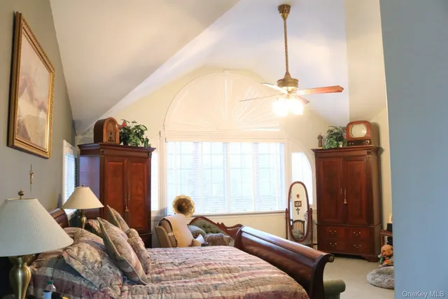 a bedroom with a bed and large windows