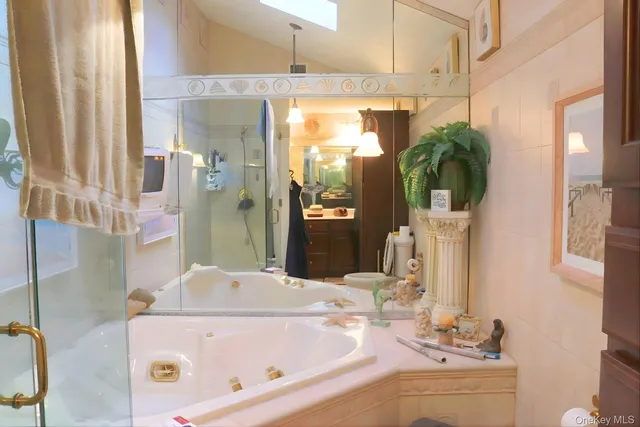 a bathroom with a tub sink and mirror