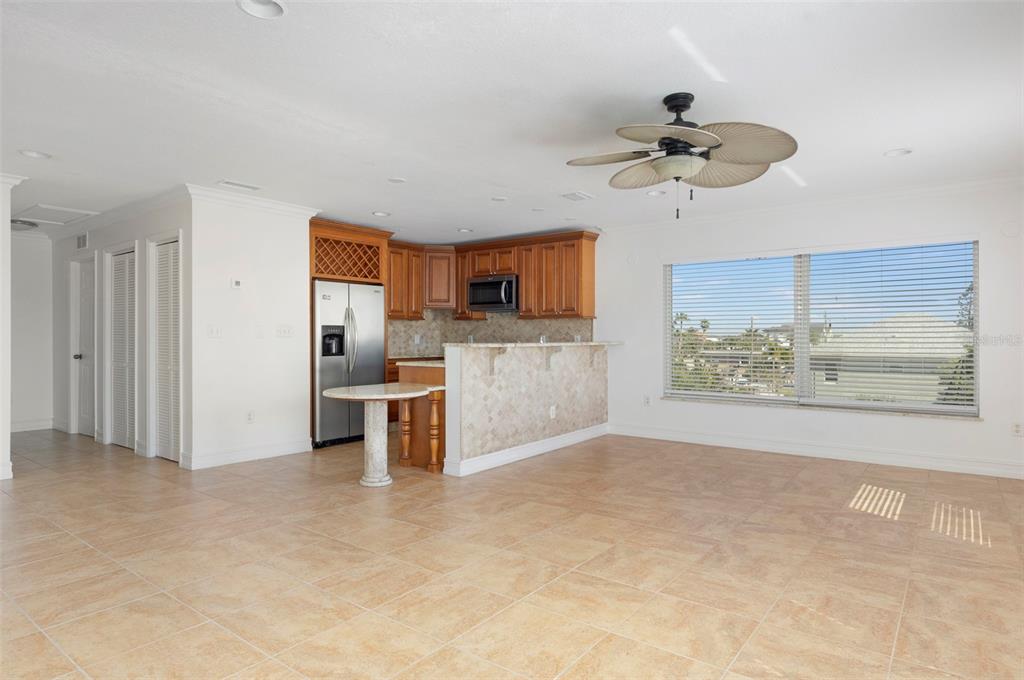 114 143rd Avenue, Unit B Madeira Beach, FL 33708 - Photo 4 of 14 a view of a kitchen with a stove cabinets a ceiling fan and wooden floor