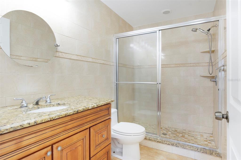 114 143rd Avenue, Unit B Madeira Beach, FL 33708 - Photo 10 of 14 a bathroom with a granite countertop sink toilet and shower