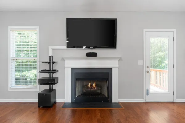 a living room with a fireplace a flat screen tv and a window
