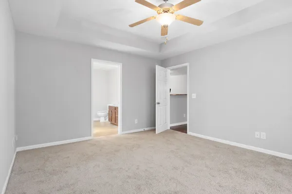 a view of an empty room with a chandelier fan