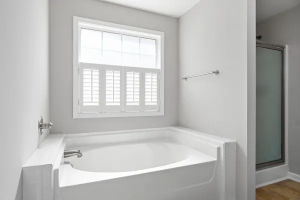 a white bath tub sitting in a bathroom next to a window