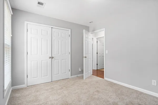 an empty room with windows and closet
