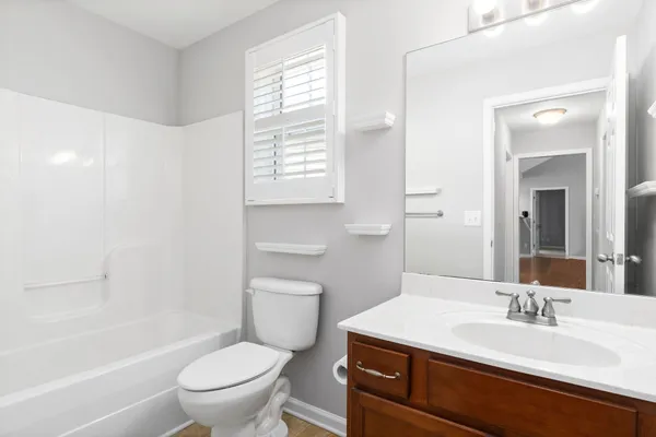 a bathroom with a granite countertop sink toilet a mirror and bathtub