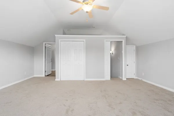 an empty room with a ceiling fan and a window