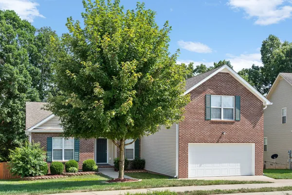 a front view of a house with a yard and garage