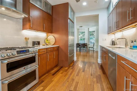 a kitchen with granite countertop wooden floors and stainless steel appliances