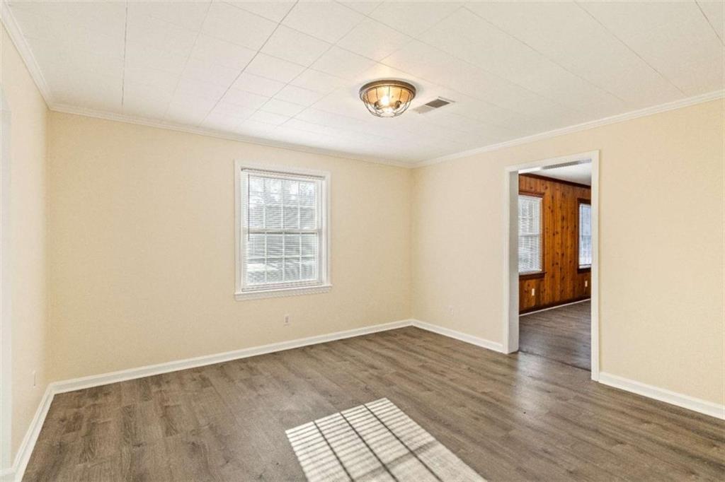 614 Burnett Ferry Road Southwest Rome, GA 30165 - Photo 4 of 29 a view of an empty room with wooden floor and a window