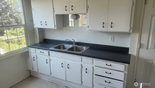 a bathroom with a granite countertop toilet and a sink