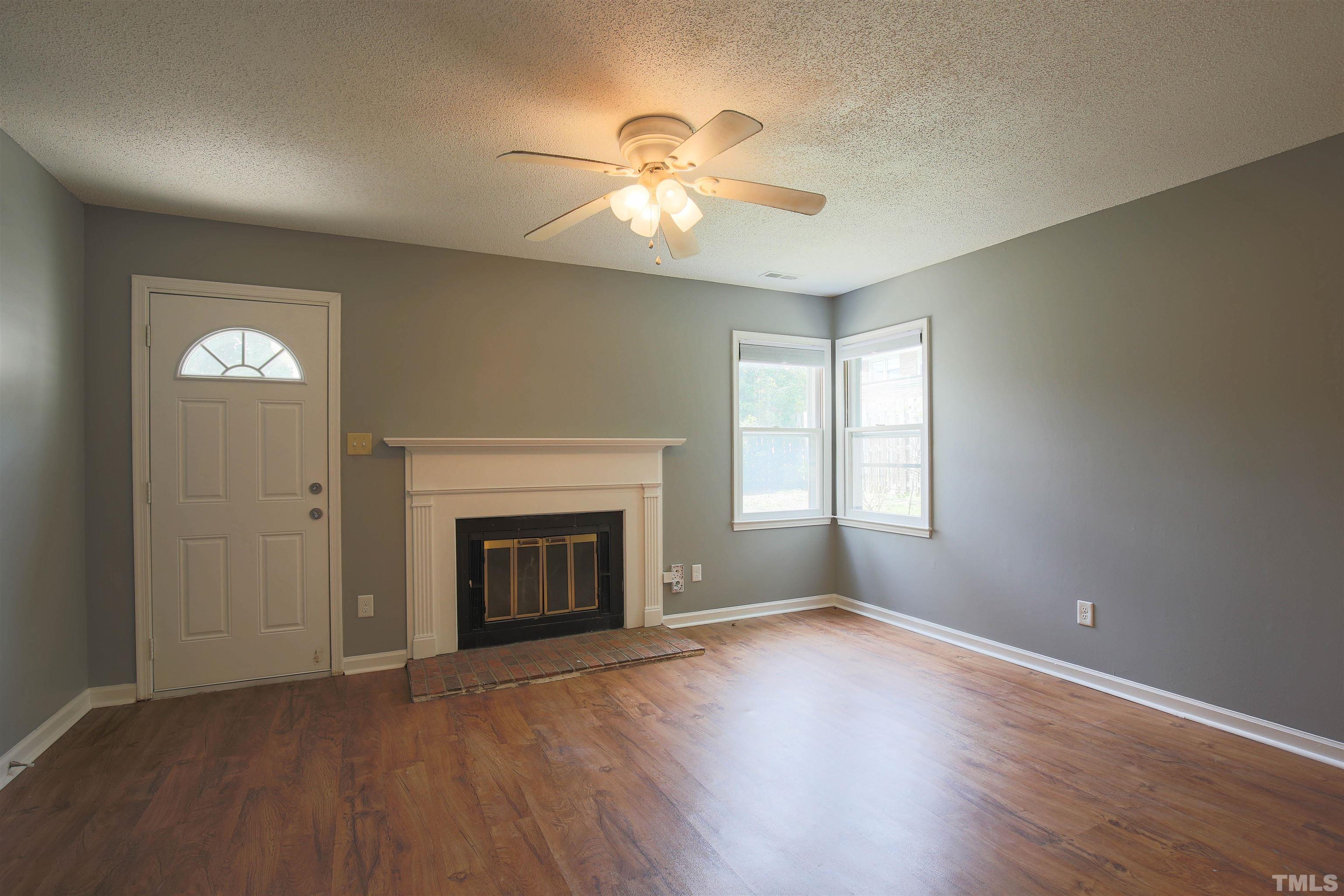 1507 Clermont Road, Unit T23 Durham, NC 27713 - Photo 3 of 24 an empty room with wooden floor fireplace and windows
