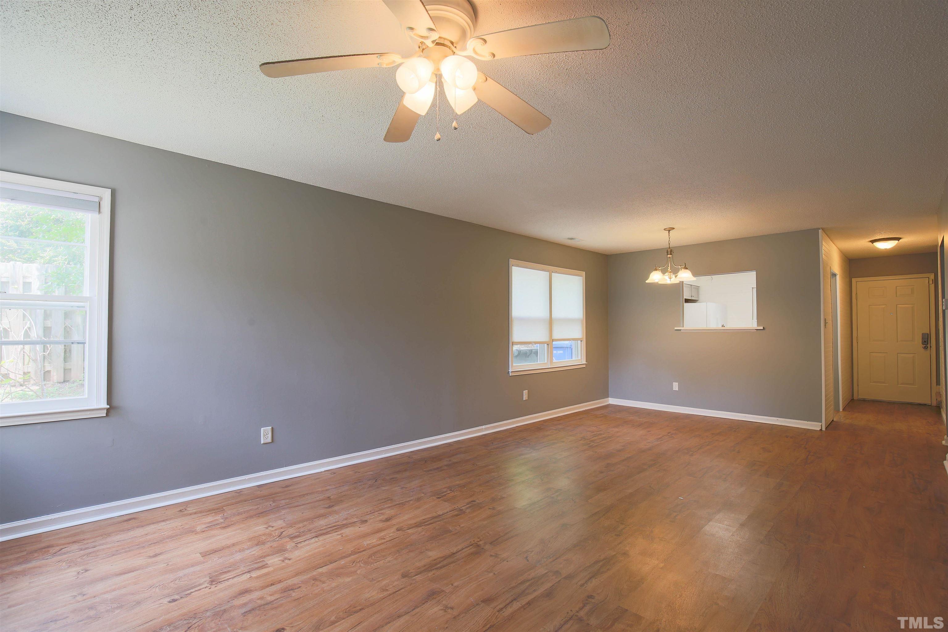 1507 Clermont Road, Unit T23 Durham, NC 27713 - Photo 4 of 24 an empty room with windows and chandelier fan