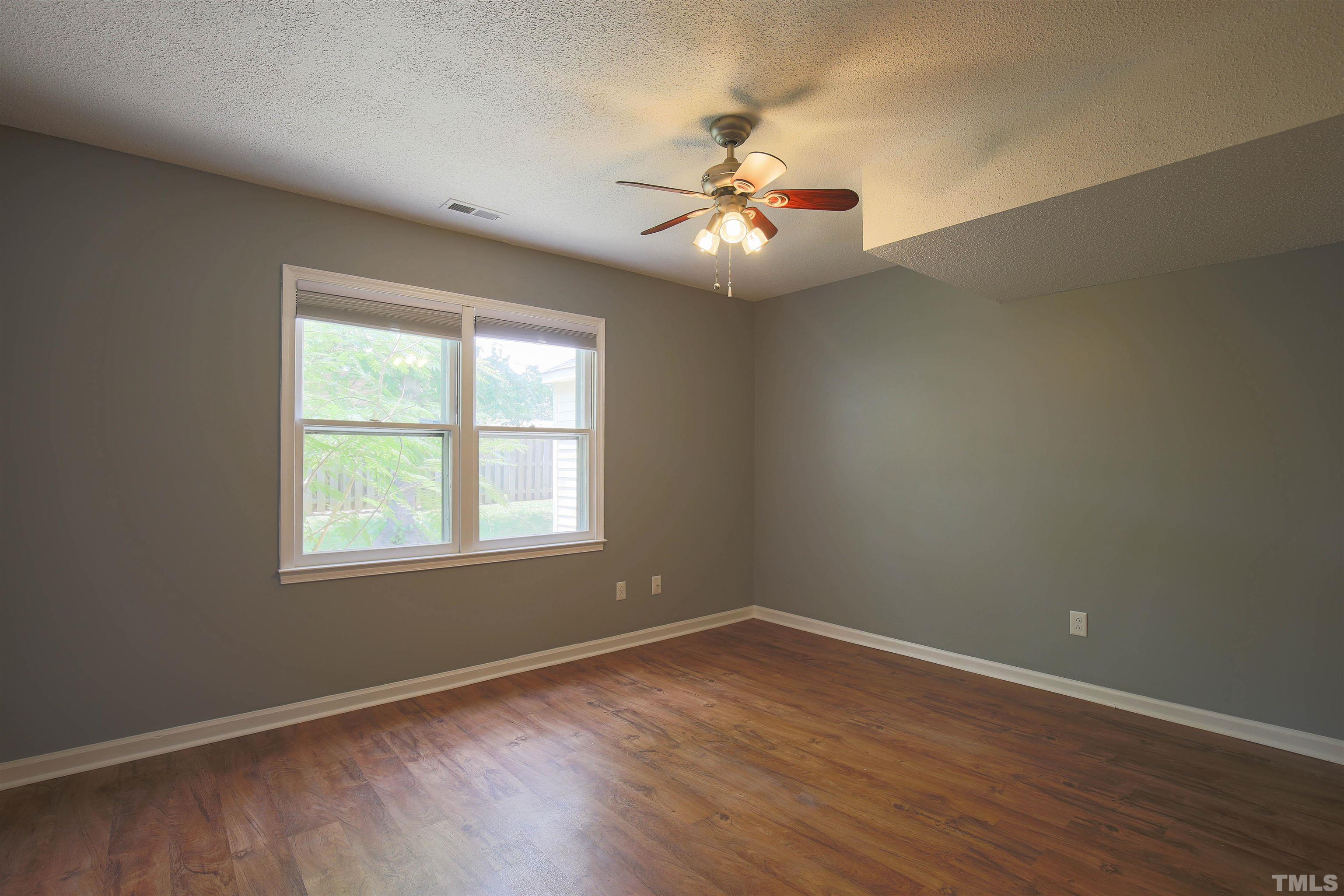 1507 Clermont Road, Unit T23 Durham, NC 27713 - Photo 10 of 24 an empty room with wooden floor fan and windows
