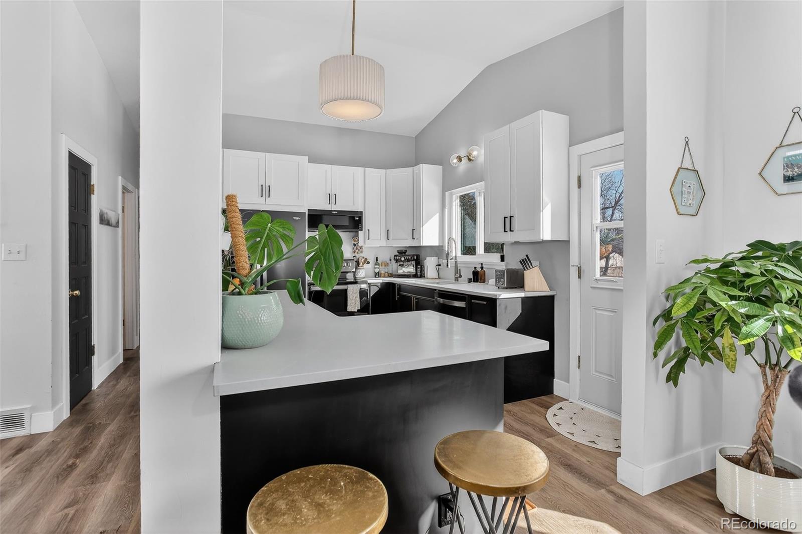 490 Quentin Street Aurora, CO 80011 - Photo 11 of 38 a kitchen with a refrigerator a stove a sink and a potted plant