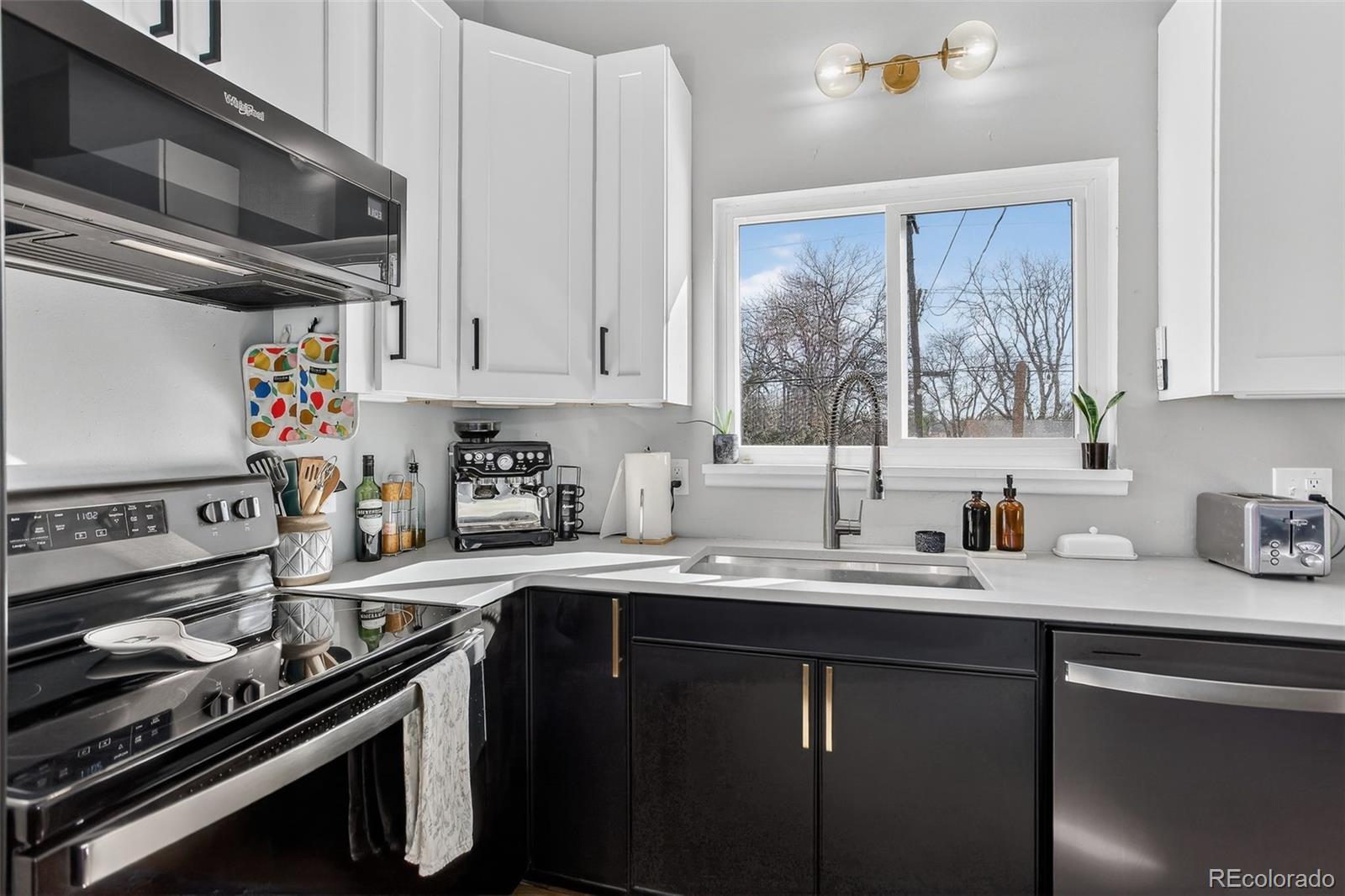 490 Quentin Street Aurora, CO 80011 - Photo 14 of 38 a kitchen with a sink stove top oven and cabinets