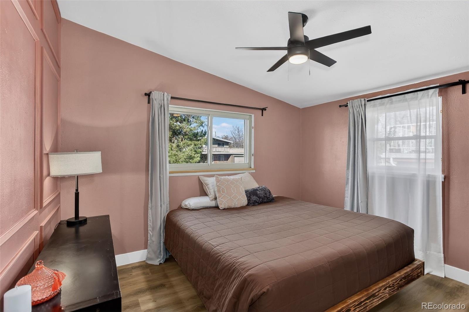 490 Quentin Street Aurora, CO 80011 - Photo 15 of 38 a bedroom with a bed and a lamp