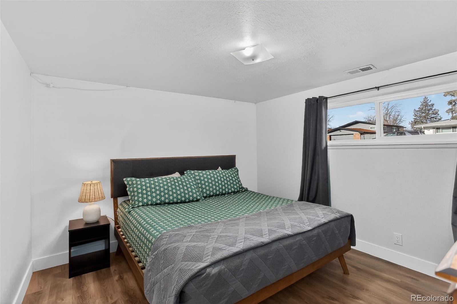 490 Quentin Street Aurora, CO 80011 - Photo 27 of 38 a bedroom with a bed and wooden floor