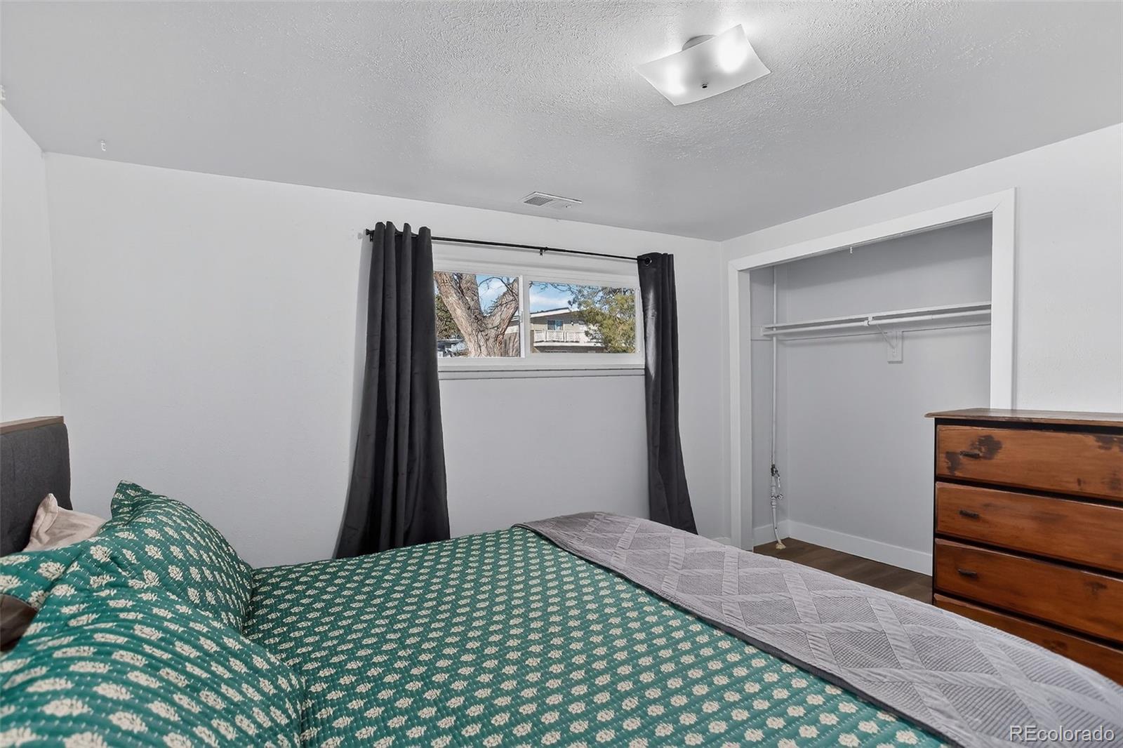 490 Quentin Street Aurora, CO 80011 - Photo 28 of 38 a bedroom with a bed and a dresser