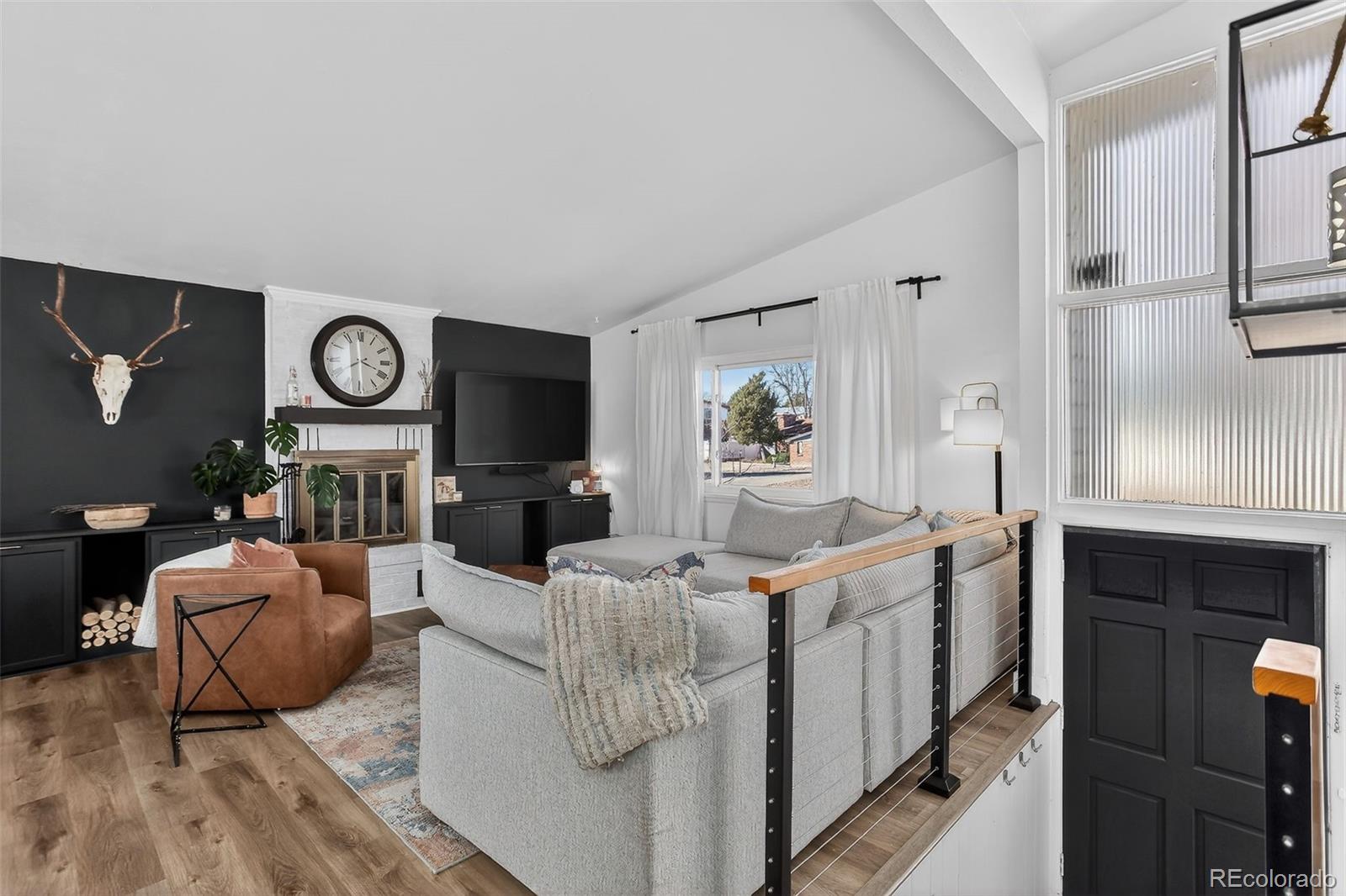 490 Quentin Street Aurora, CO 80011 - Photo 3 of 38 a living room with furniture a fireplace and a flat screen tv