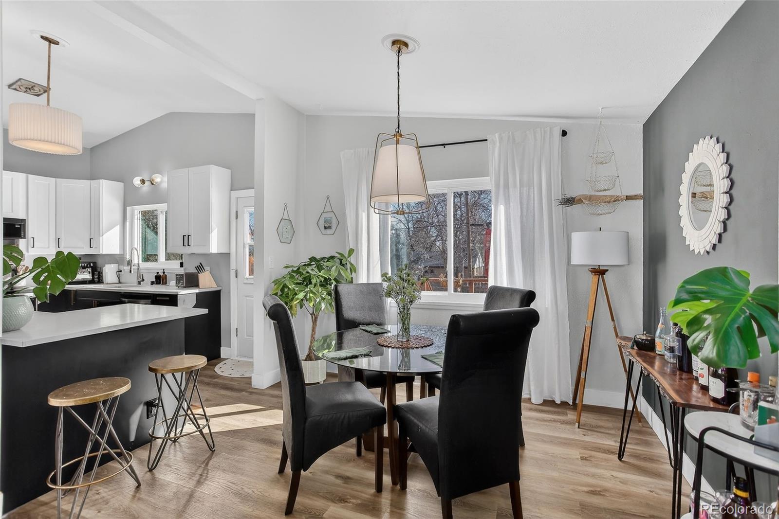 490 Quentin Street Aurora, CO 80011 - Photo 9 of 38 a dining room with furniture potted plants and wooden floor