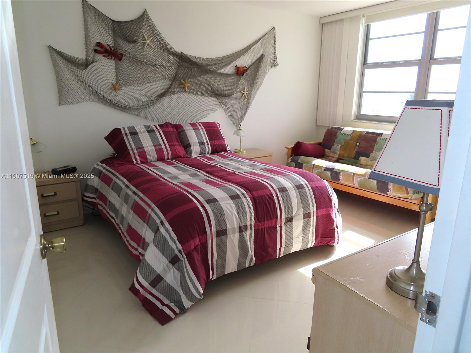 5701 Collins Avenue, Unit 304 Miami Beach, FL 33140 - Photo 13 of 42 a bedroom with a bed and window