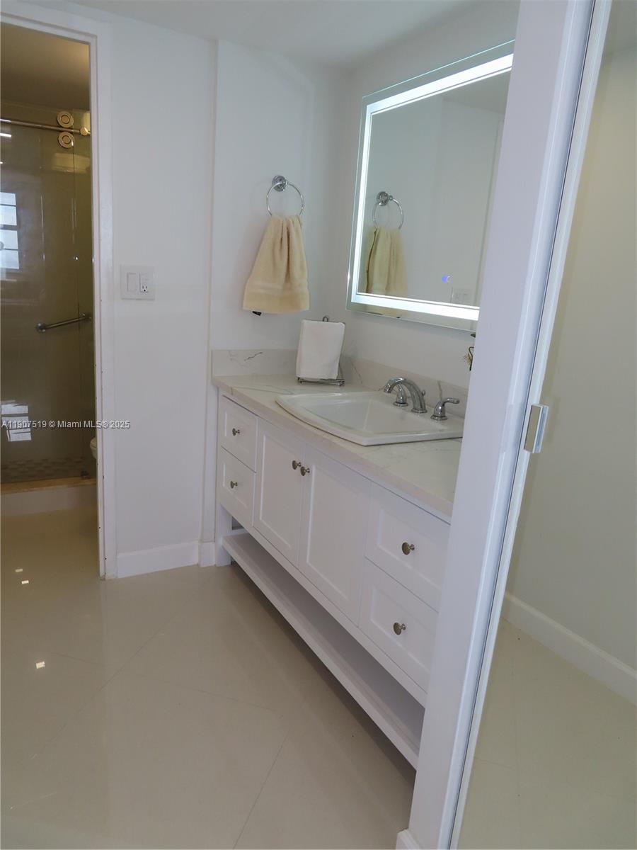5701 Collins Avenue, Unit 304 Miami Beach, FL 33140 - Photo 14 of 42 a bathroom with a sink and a mirror
