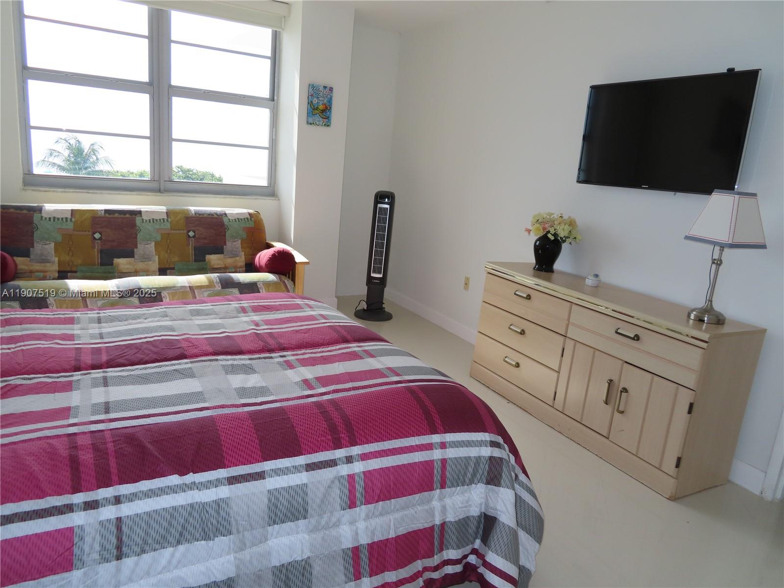 5701 Collins Avenue, Unit 304 Miami Beach, FL 33140 - Photo 18 of 42 a bedroom with a bed and flat screen tv