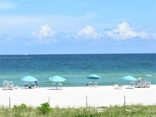 a view of ocean with lots of car parked
