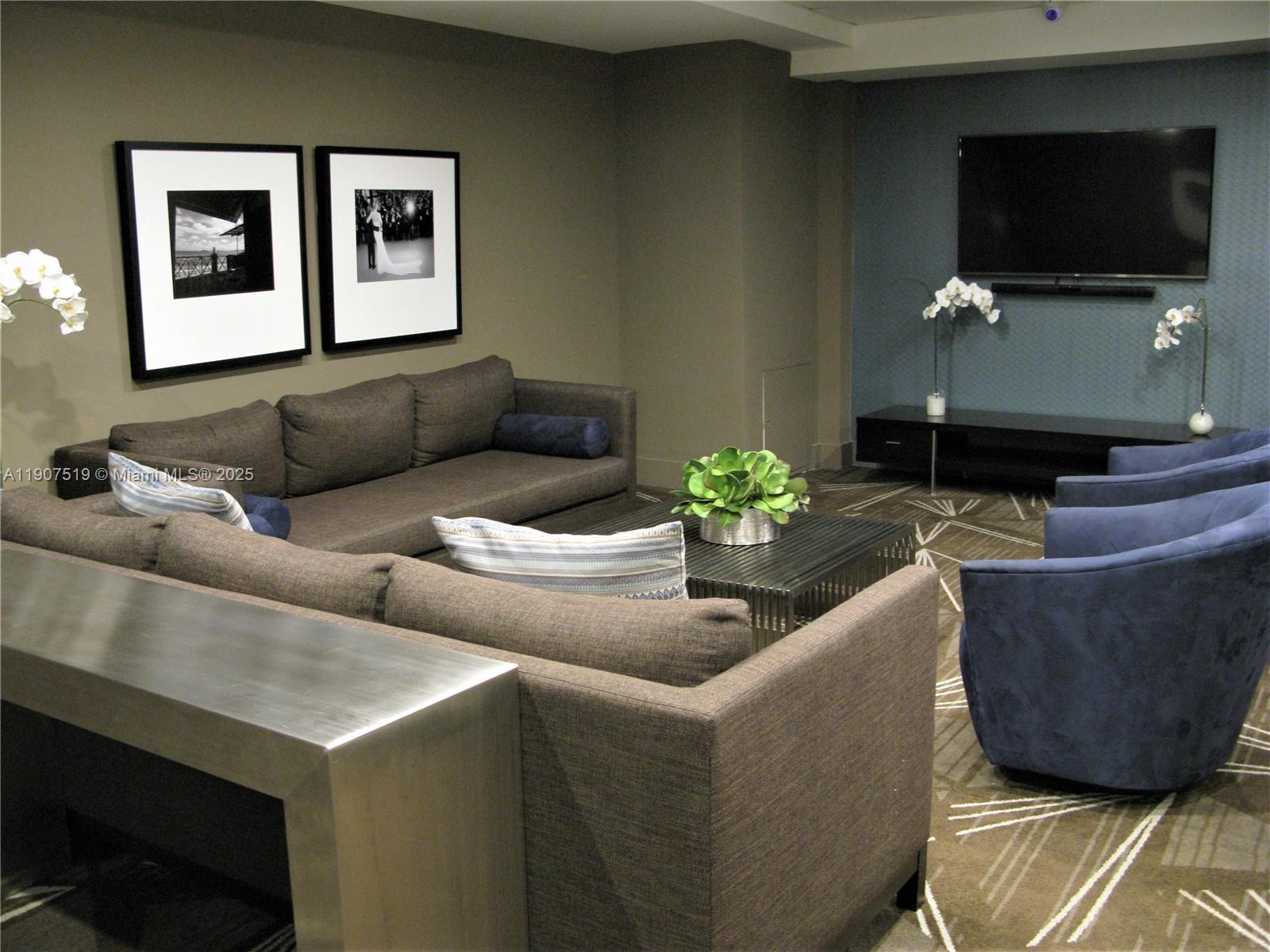 5701 Collins Avenue, Unit 304 Miami Beach, FL 33140 - Photo 35 of 42 a living room with furniture and a flat screen tv