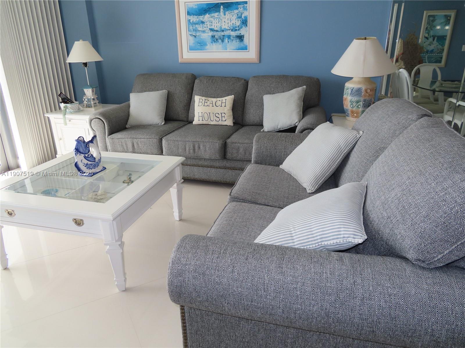 5701 Collins Avenue, Unit 304 Miami Beach, FL 33140 - Photo 9 of 42 a living room with furniture and a lamp