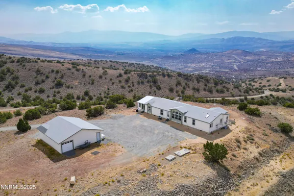 an aerial view of a house with a mountain