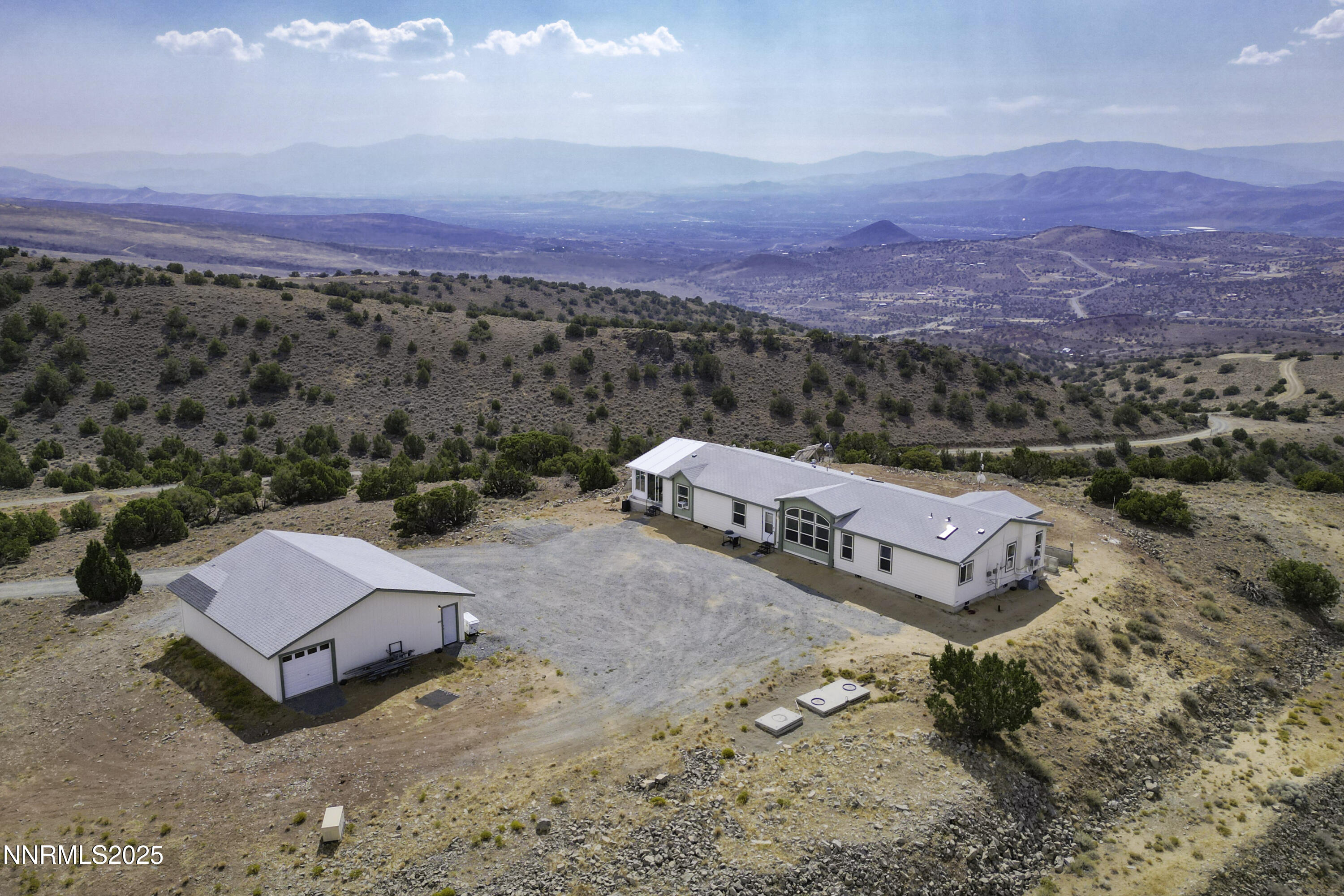 an aerial view of a house with a mountain