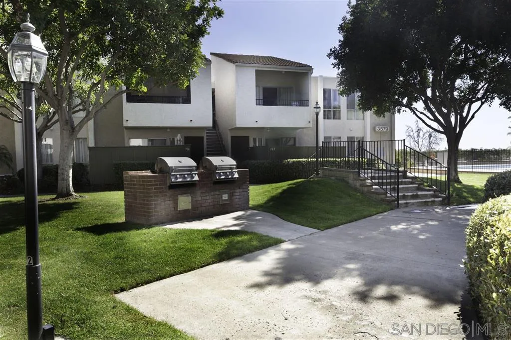 3583 Ruffin Road, Unit 214 San Diego, CA 92123 - Photo 11 of 12 a view of a backyard with couches plants and large trees