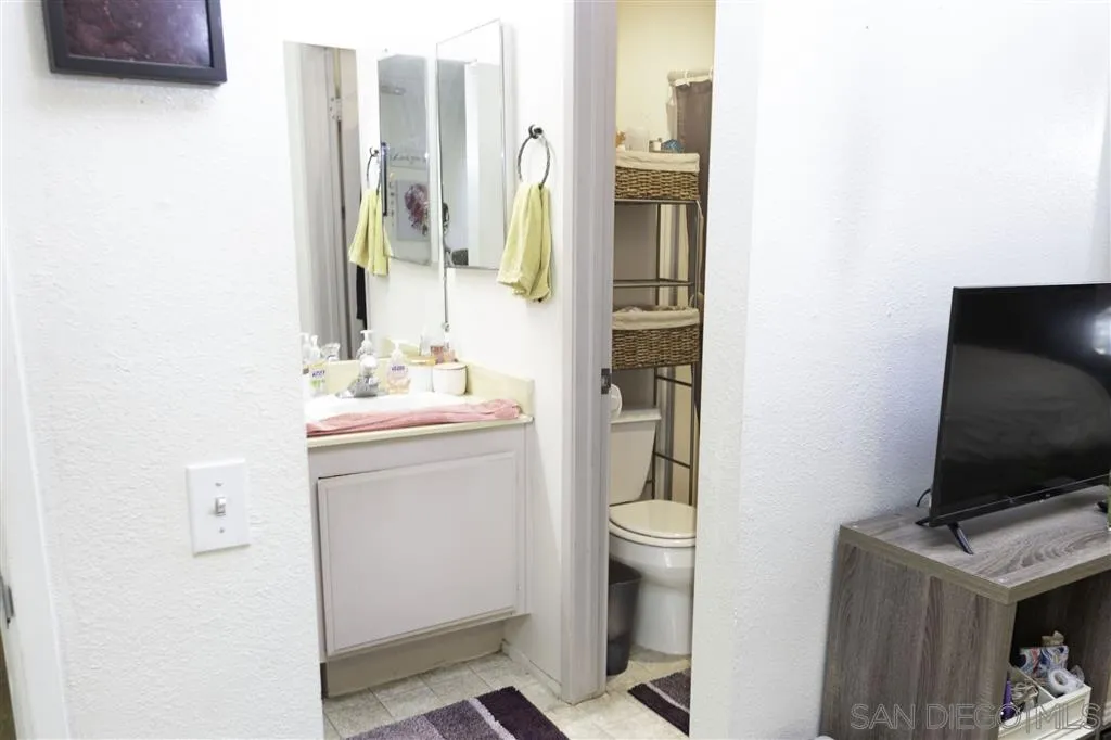 3583 Ruffin Road, Unit 214 San Diego, CA 92123 - Photo 8 of 12 a bathroom with a sink toilet and mirror