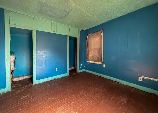 an empty room with closet and windows