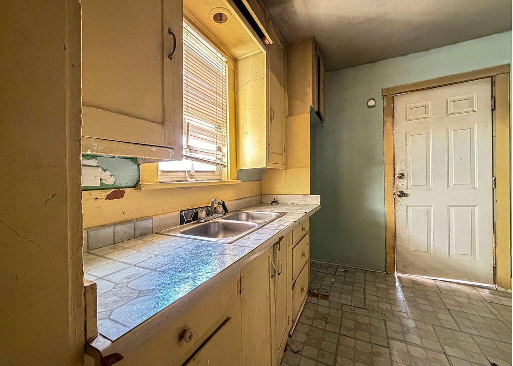 1204 Galveston Plainview, TX 79072 - Photo 7 of 12 a kitchen with a sink and a refrigerator