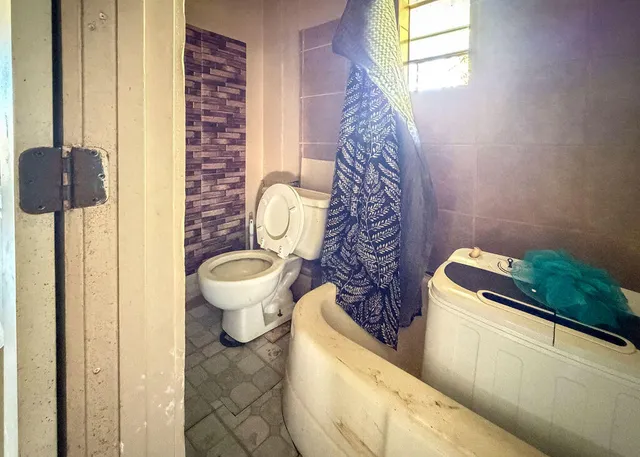 a bathroom with a toilet and a shower curtain