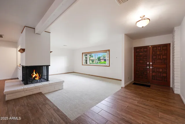 a view of an empty room with a fireplace and a window