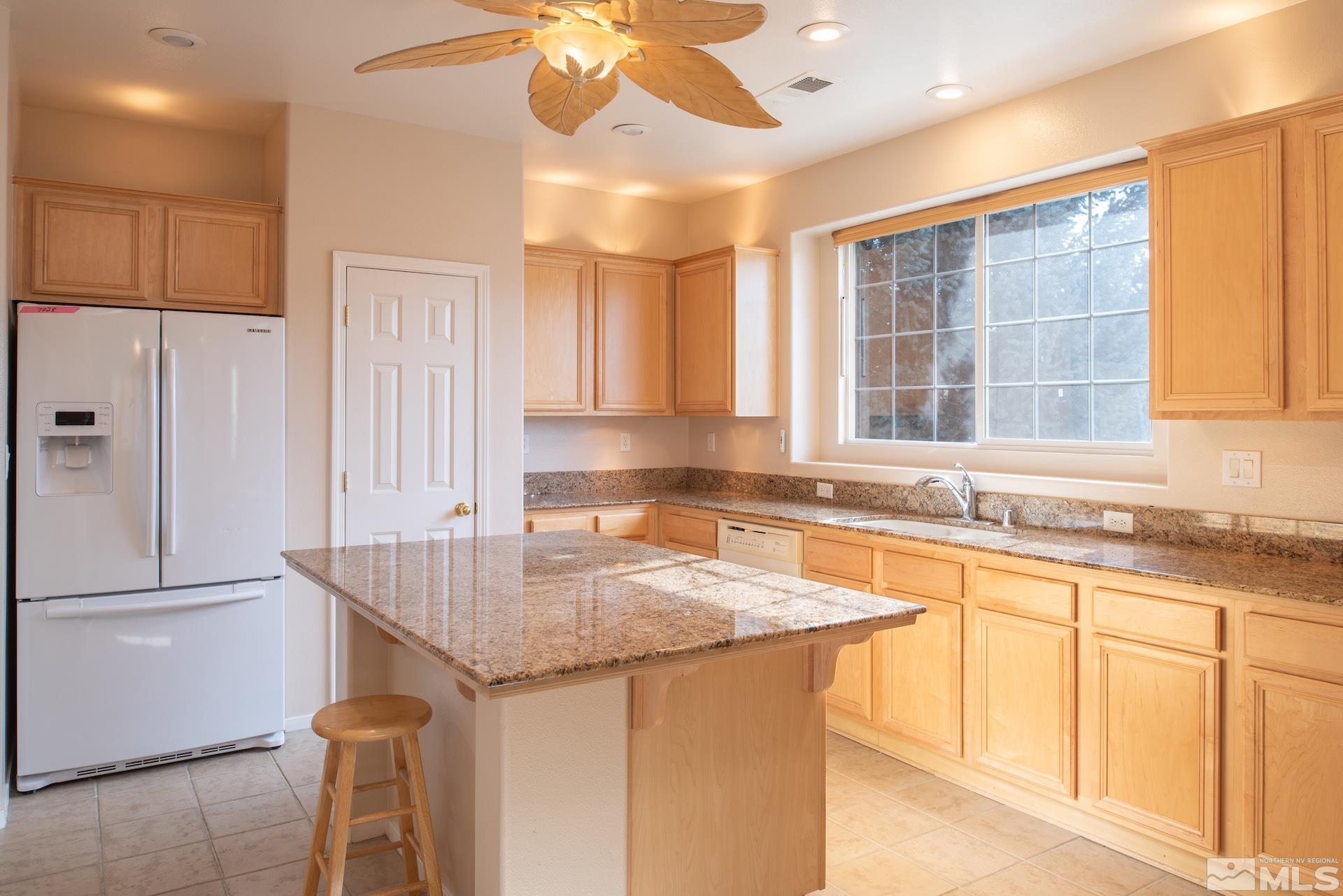 10175 Donner Peak Drive Reno, NV 89521 - Photo 14 of 35 a kitchen with granite countertop a sink and a refrigerator