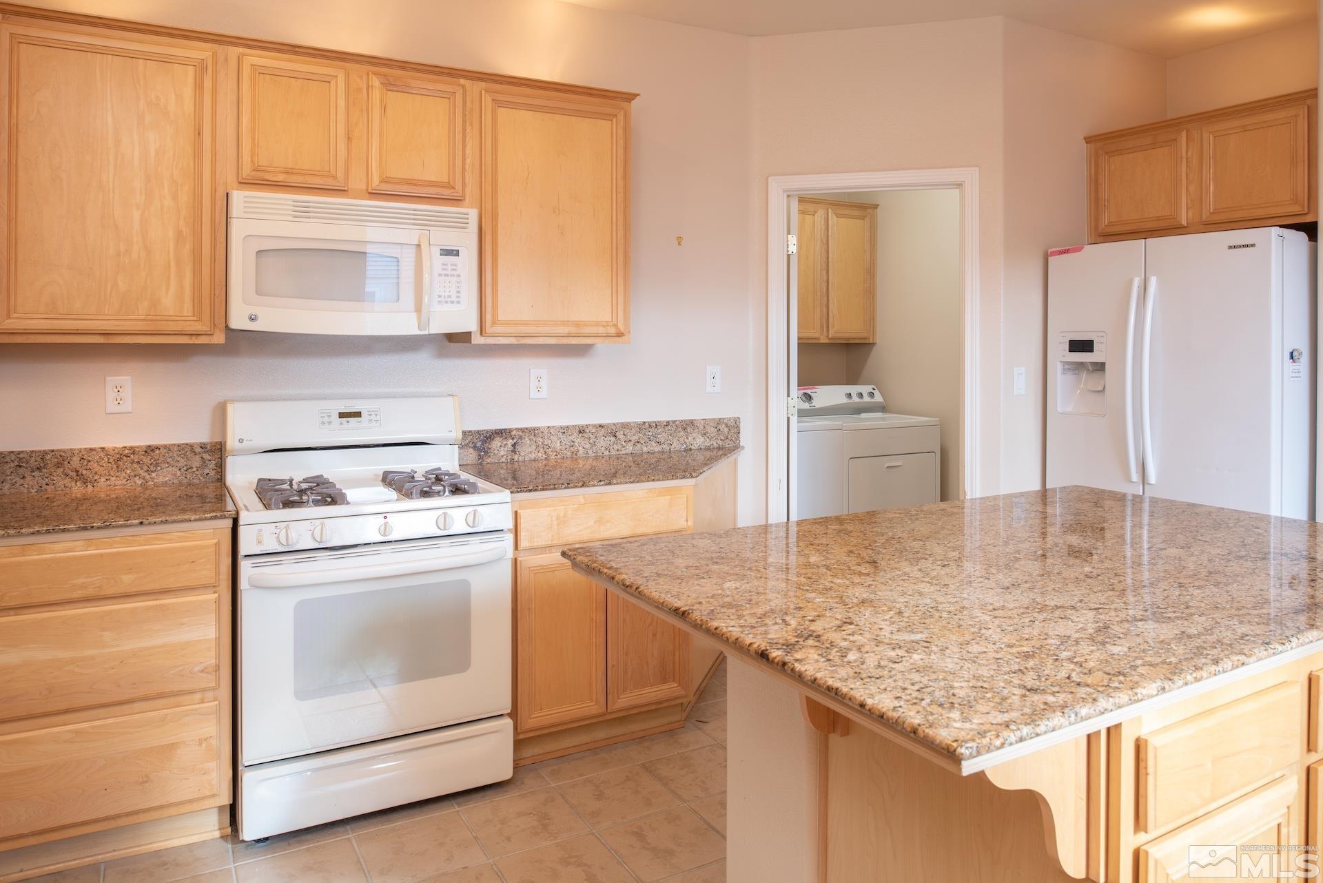10175 Donner Peak Drive Reno, NV 89521 - Photo 15 of 35 a kitchen with stainless steel appliances granite countertop a sink stove and refrigerator