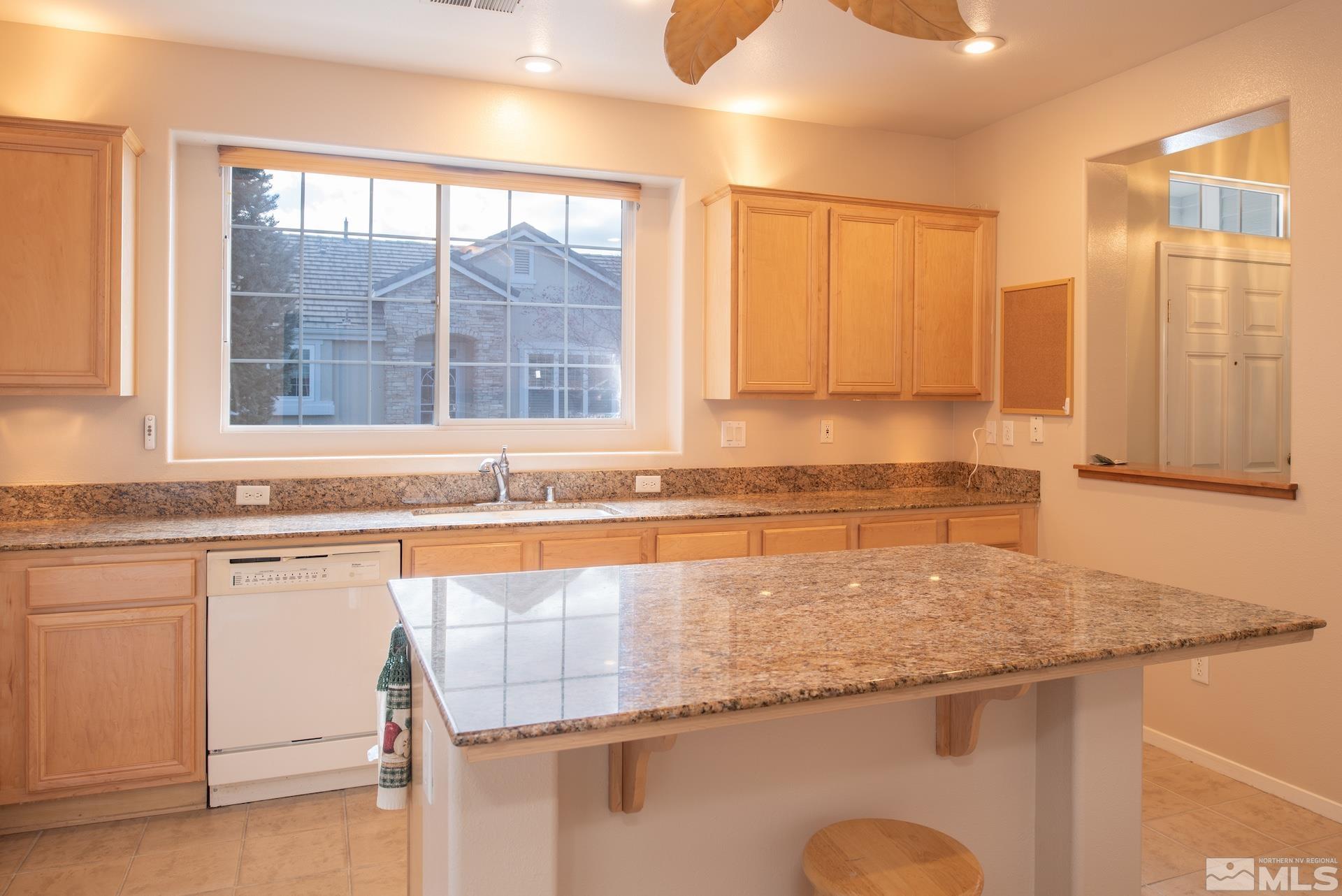 10175 Donner Peak Drive Reno, NV 89521 - Photo 16 of 35 a kitchen with granite countertop sink and window