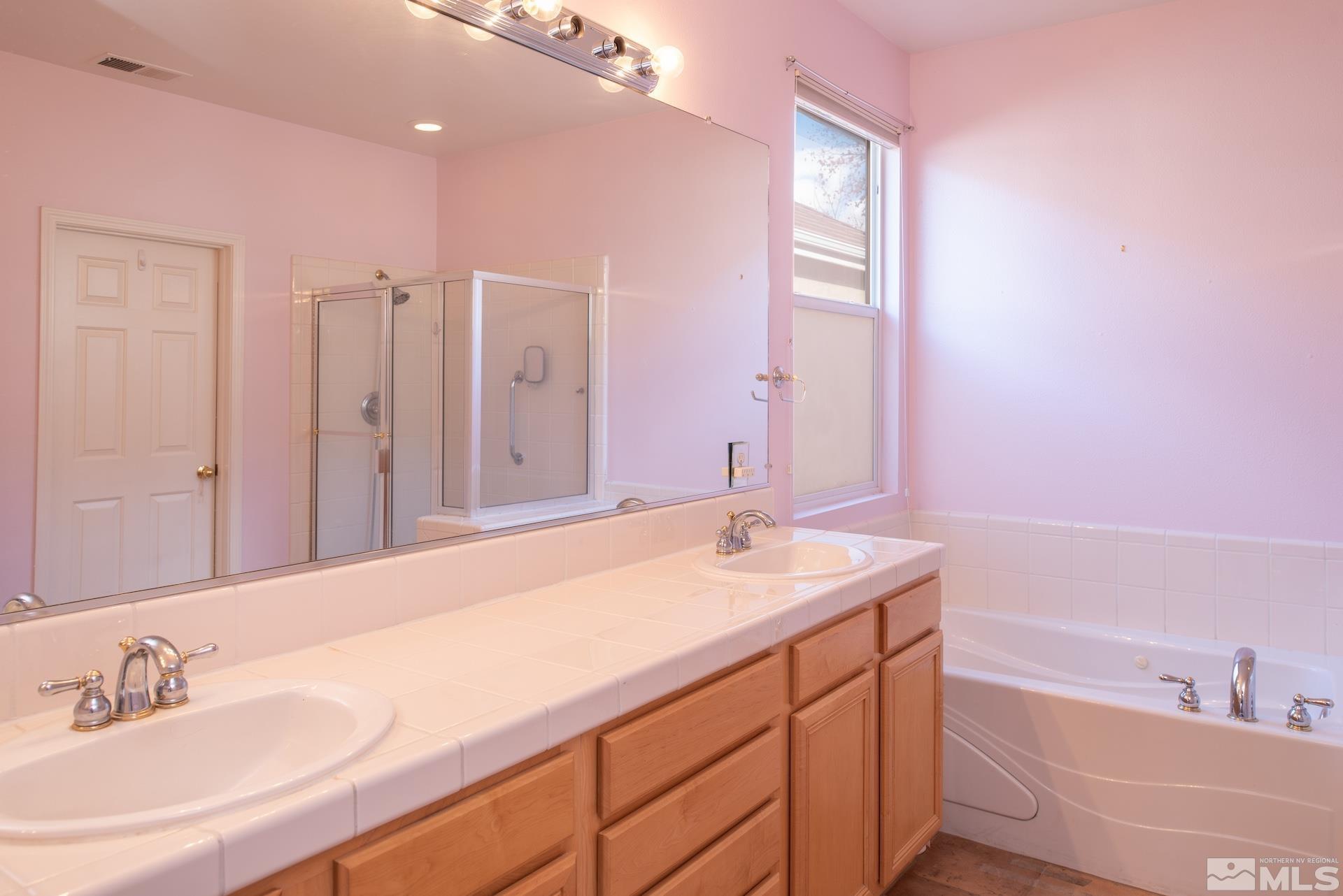 10175 Donner Peak Drive Reno, NV 89521 - Photo 21 of 35 a bathroom with a granite countertop sink and a bathtub
