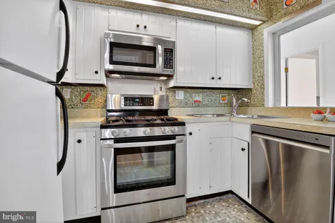 a kitchen with stainless steel appliances a stove microwave and sink