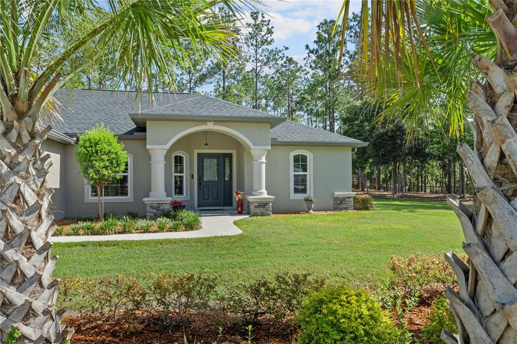 12929 Southwest 89th Street Dunnellon, FL 34432 - Photo 34 of 76 a front view of a house with a garden