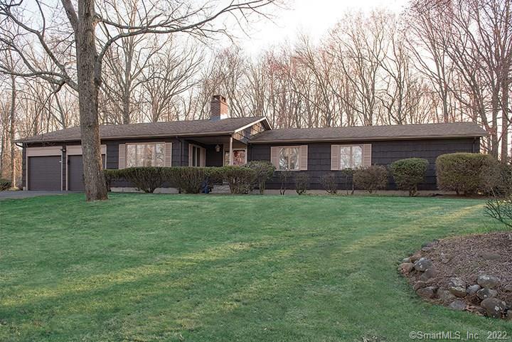 a front view of a house with a garden and trees
