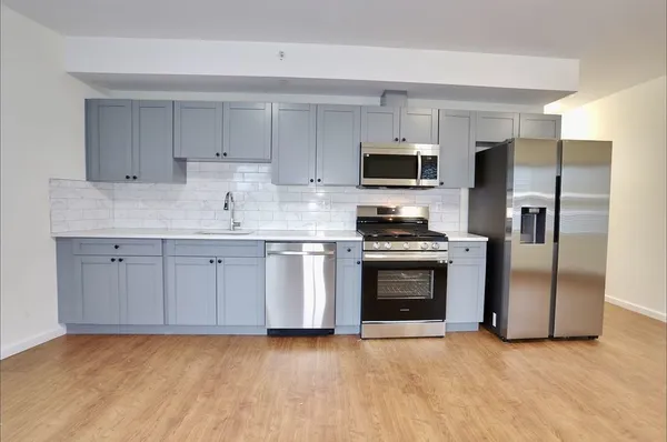 a kitchen with stainless steel appliances a stove a sink and a refrigerator