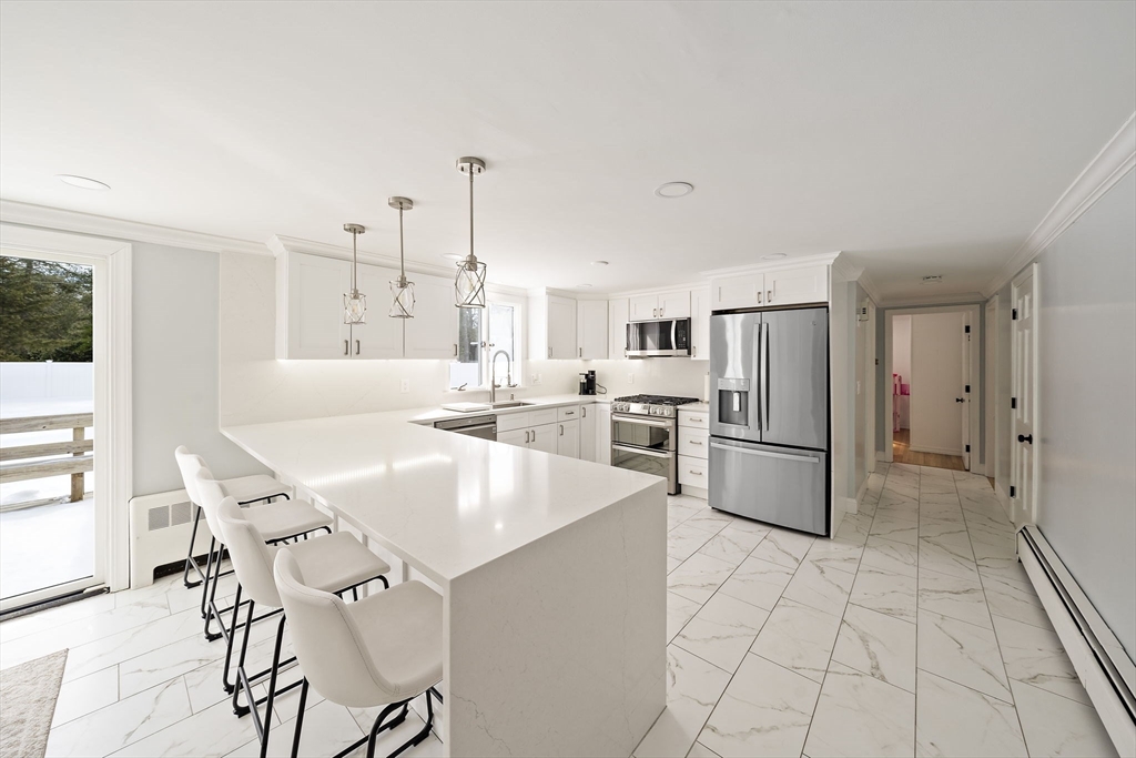 10 Dowd Avenue Wareham, MA 02571 - Photo 4 of 42 a kitchen with stainless steel appliances a refrigerator a stove a sink and white cabinets